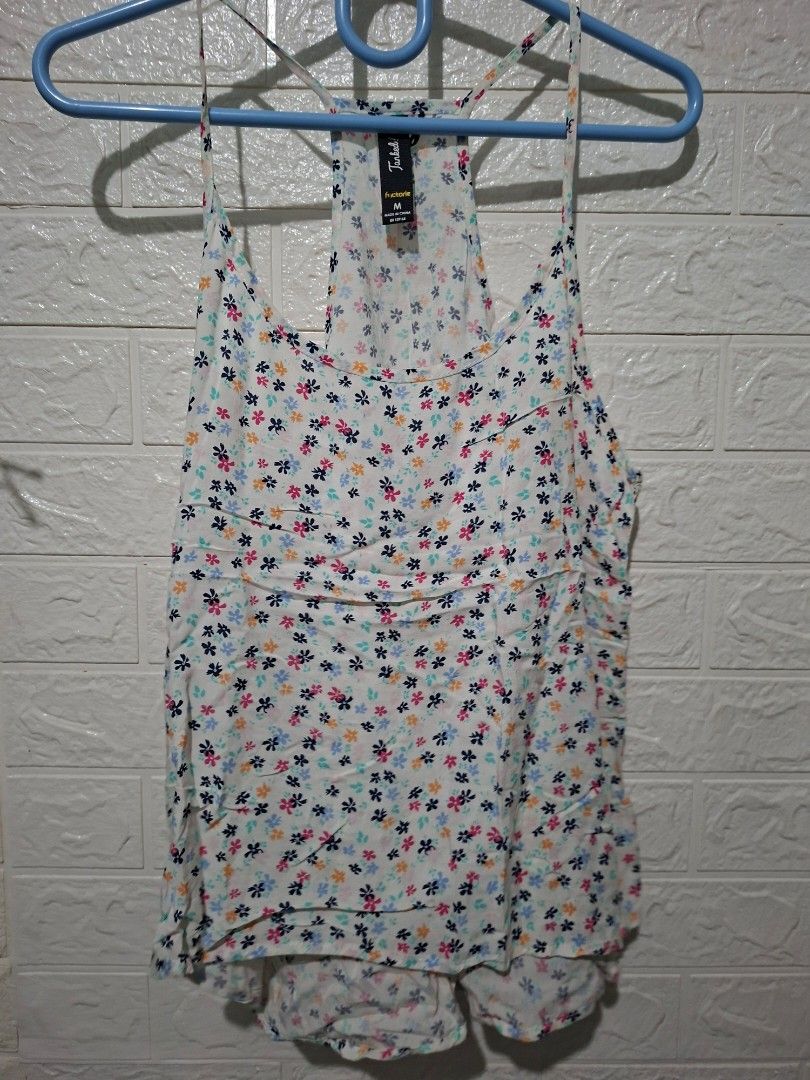 Factorie White floral print top with tie straps (Category: Sleeveless) located in Talisay. Submitted by zhi_nel (Listing ID 1446488080, Image 1). Description: - Cute white top with a delicate floral print. - Features thin, adjustable tie straps. - Made from light and airy fabric, perfect for warm weather. - Versatile for casual wear or layering. - Estimated size: Small to Medium. from New Zealand 🇳🇿.