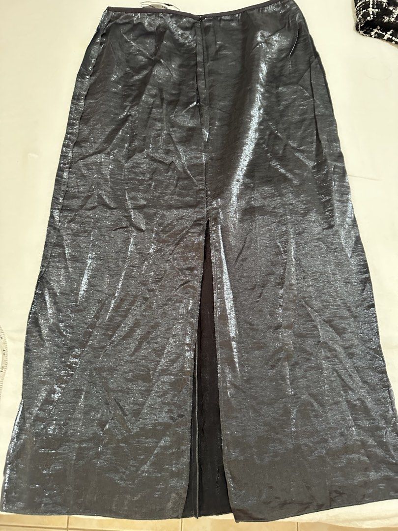 Zara Metallic Midi Skirt with Slit (Category: Skirts) located in Balanga. Submitted by ruffa_assorted_item (Listing ID 1446401666, Image 2). Description: - Size: W30 L 35 - Zara metallic midi skirt - Features a front slit - Back zipper closure - Versatile for dressing up or down - Brand new with original tags attached.