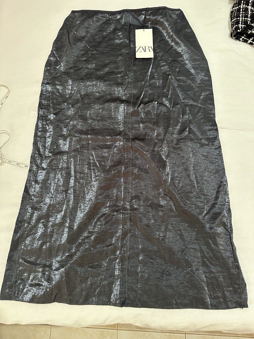Zara Metallic Midi Skirt with Slit (Category: Skirts) located in Balanga. Submitted by ruffa_assorted_item (Listing ID 1446401666, Image 1). Description: - Size: W30 L 35 - Zara metallic midi skirt - Features a front slit - Back zipper closure - Versatile for dressing up or down - Brand new with original tags attached.