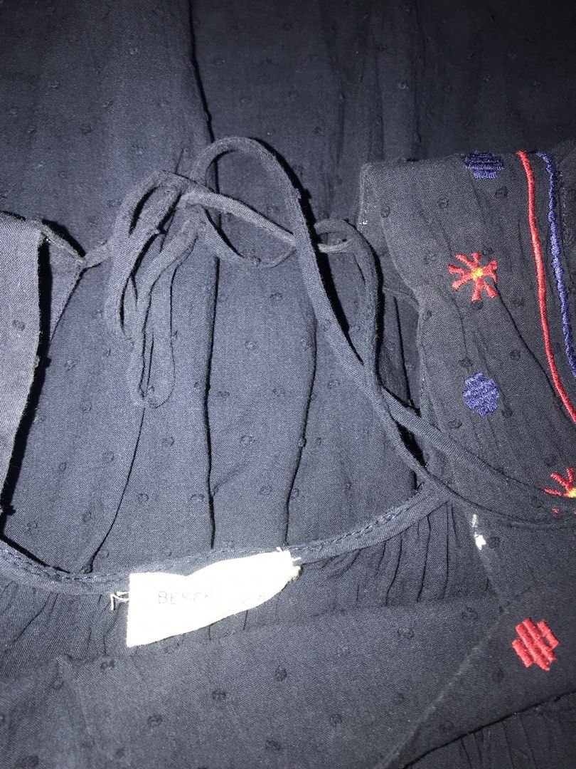 Bench Navy Embroidered Peasant Top with Tie Neck (Category: Blouses) located in Pasig City. Submitted by papotzy (Listing ID 1446671687, Image 3). Description: - Navy blue peasant top - Textured dot fabric - Square neckline with red and blue floral embroidery on yoke - Ties at the back of the neck - Flutter sleeves - Ideal for casual wear.