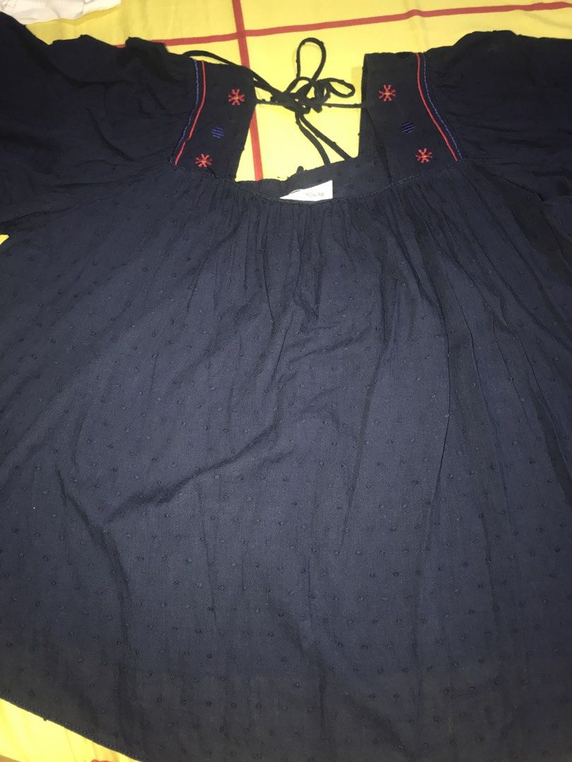 Bench Navy Embroidered Peasant Top with Tie Neck (Category: Blouses) located in Pasig City. Submitted by papotzy (Listing ID 1446671687, Image 2). Description: - Navy blue peasant top - Textured dot fabric - Square neckline with red and blue floral embroidery on yoke - Ties at the back of the neck - Flutter sleeves - Ideal for casual wear.