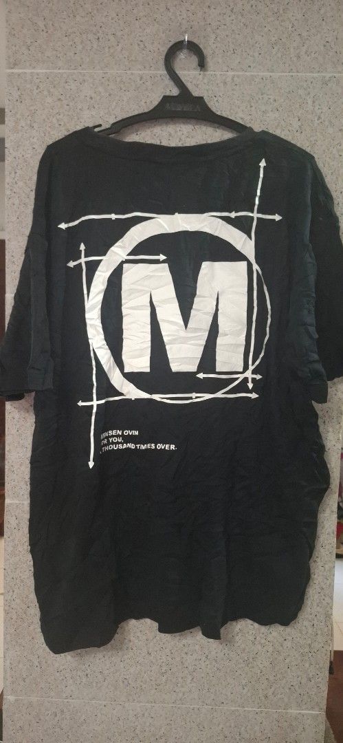 Black T-shirt with White Graphic Print (Category: Tshirts & Polo Shirts ) located in Tumauini. Submitted by kk_323 (Listing ID 1446570731, Image 2). Description: - Black t-shirt with striking white graphic design. - Features a large 'M' within a circle and geometric line art. - Graphic present on both front and back. - Ideal for everyday casual wear..