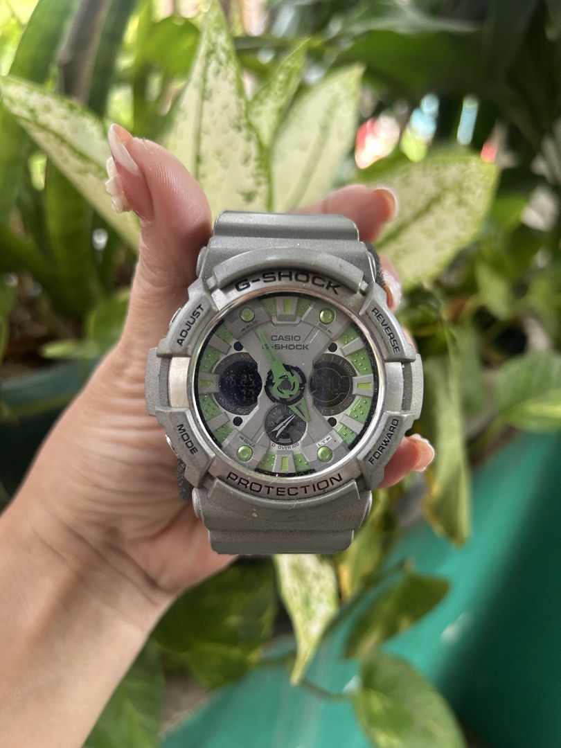 Casio G-Shock Watch Green Accents (Category: Men's Watches) located in Cavite. Submitted by mamamia73 (Listing ID 1446605778, Image 3). Description: Grey G-Shock watch with green accents on the face. Digital and analog display. Water resistant 20 BAR. Shock resistant. Comes with original box. Great for everyday wear and outdoor activities..