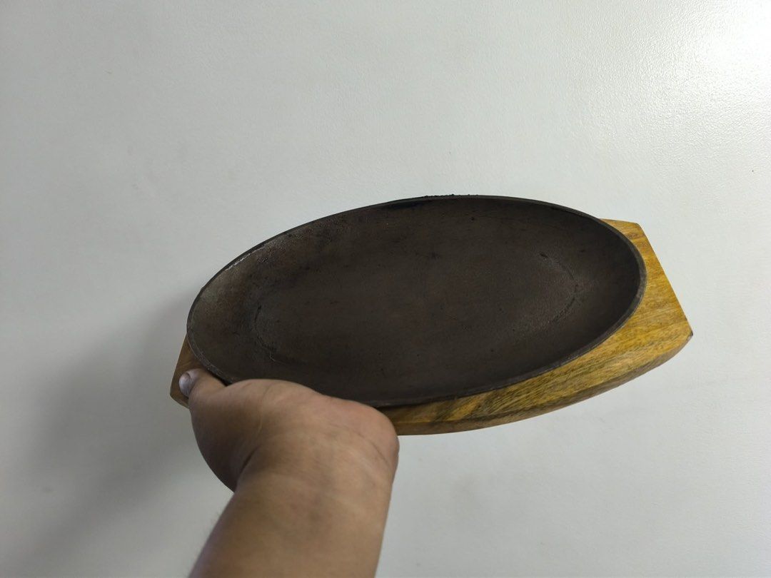 Cast Iron Sizzling Plates with Wooden Base (Category: Cookware & Accessories) located in Taguig. Submitted by treizie (Listing ID 1446575779, Image 2). Description: - Set of cast iron sizzling plates with wooden bases - Keeps food hot for longer - Protects surfaces with wooden base - Great for serving directly from oven/stovetop - Suitable for restaurant or home use - Multiple sets available.