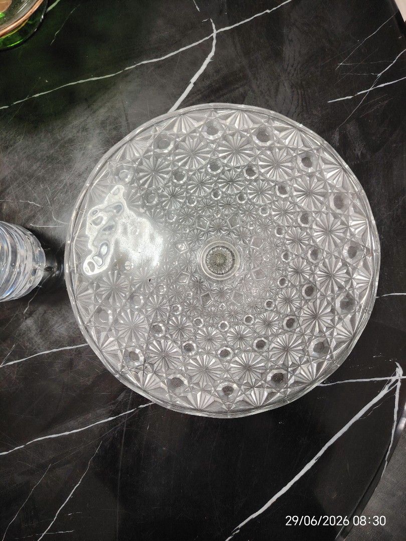 Clear Glass Cake Stand with Intricate Pattern (Category: Other Kitchenware & Tableware) located in Petaling Jaya. Submitted by junkerwalk (Listing ID 1446547031, Image 1). Description: - Beautiful clear glass cake stand - Features an all-over geometric pattern - Ideal for displaying cakes, desserts, or pastries - Doubles as a decorative centerpiece - Sturdy and well-made construction - Perfect for parties or everyday use - The item is almost 19 y