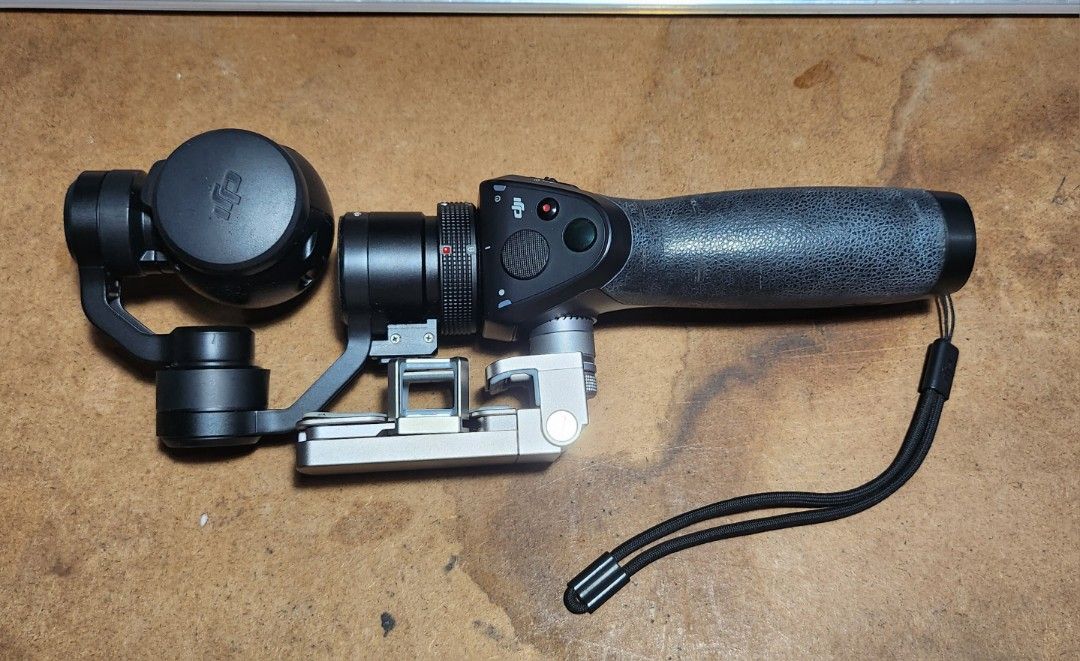 DJI Osmo Handheld Gimbal Stabilizer with Accessories (Category: Gimbals & Stabilizers ) located in Caloocan City. Submitted by julsbaldo (Listing ID 1446673562, Image 3). Description: - DJI Osmo handheld gimbal stabilizer - Includes: Gimbal, handle, camera lens cap, charging dock, 2 batteries, carrying case - Bonus: Green DJI stand included - Achieve smooth, professional-looking video footage - Ready for your next creative project.