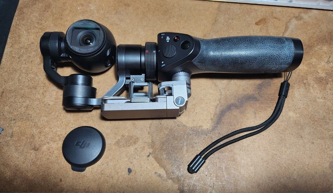 DJI Osmo Handheld Gimbal Stabilizer with Accessories (Category: Gimbals & Stabilizers ) located in Caloocan City. Submitted by julsbaldo (Listing ID 1446673562, Image 2). Description: - DJI Osmo handheld gimbal stabilizer - Includes: Gimbal, handle, camera lens cap, charging dock, 2 batteries, carrying case - Bonus: Green DJI stand included - Achieve smooth, professional-looking video footage - Ready for your next creative project.
