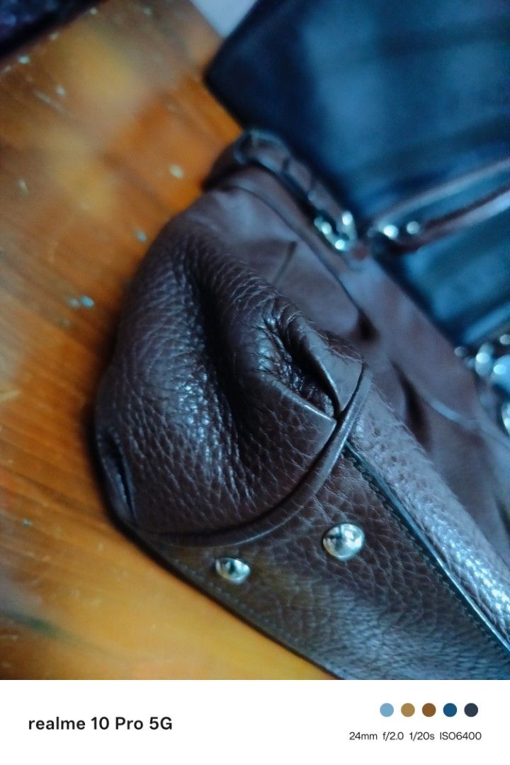 Ferragamo Brown Leather Shoulder Bag (Category: Shoulder Bags) located in Manila. Submitted by cleverturtle-2982 (Listing ID 1446622602, Image 2). Description: - Stylish brown pebbled leather shoulder bag - Features decorative buckle details on the sides - Double handles for comfortable carrying - Ample interior space for all your essentials - Ideal for everyday use - Shows some signs of wear, but remains in good overall shape.