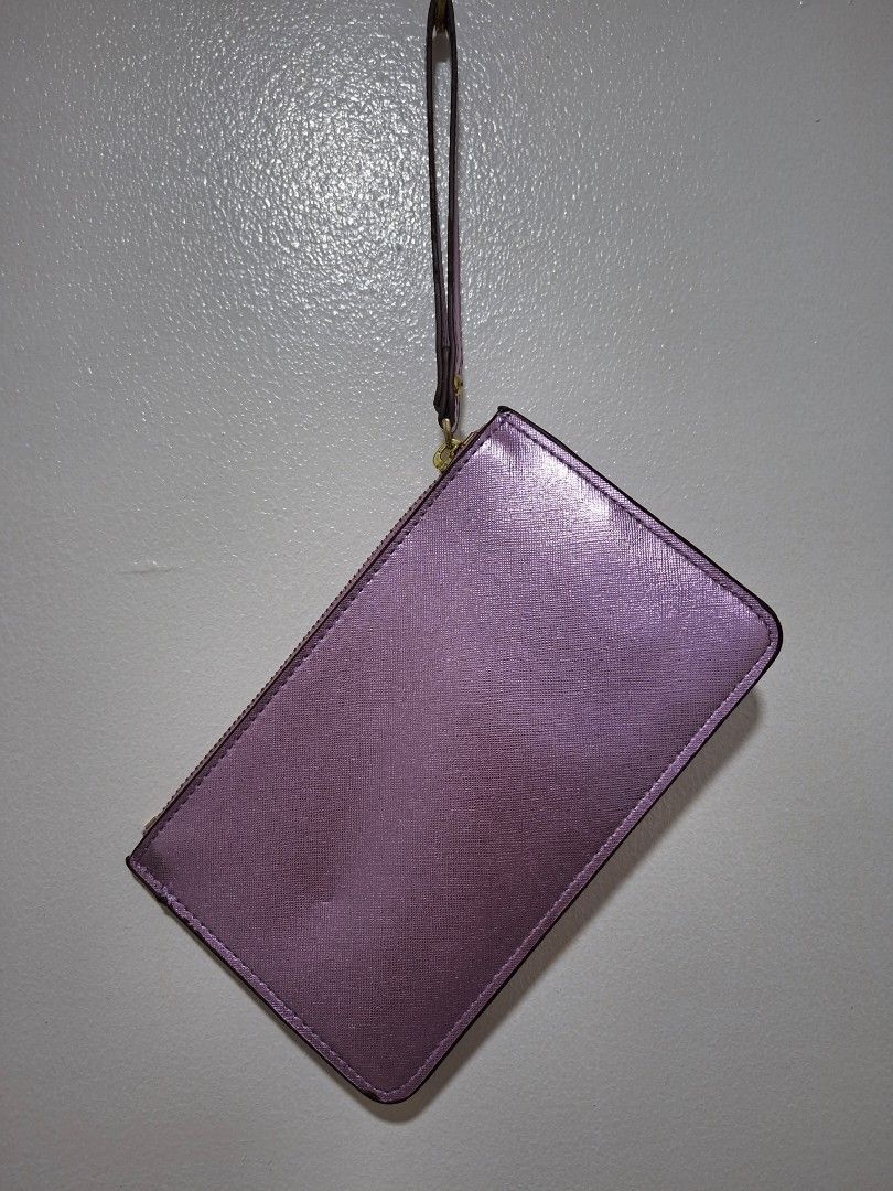 Kate Spade Metallic Purple Wristlet Pouch (Category: Purses & Pouches) located in Cabanatuan. Submitted by riworks (Listing ID 1446691469, Image 2). Description: - 20cm width and 12cm length - Kate Spade wristlet pouch - Metallic purple with textured finish - Zipper closure - Interior features classic Kate Spade spade pattern lining - Small wrist strap attached - Ideal for carrying essentials.