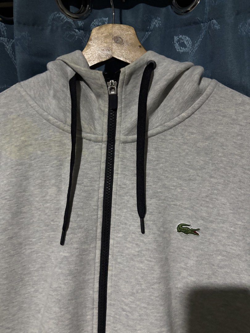 Lacoste Grey Zip-Up Hoodie (Category: Hoodies) located in Cebu City. Submitted by somewhereintime_ (Listing ID 1446659732, Image 2). Description: - Grey Lacoste zip-up hoodie - Signature crocodile logo on chest - Full zip closure - Front pockets - Attached hood - Ideal for casual wear.