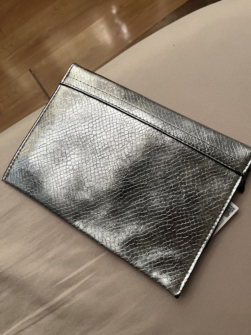 Mango Silver Snake Print Clutch Bag (Category: Clutches) located in Manila. Submitted by austinver91082 (Listing ID 1446543340, Image 2). Description: RFS : Decluttering - Chic silver clutch bag - Eye-catching snake print texture - Secure fold-over flap closure - Lined interior with Mango brand tag - Brand new with original tag attached - Ideal for evening events or adding flair to any outfit.