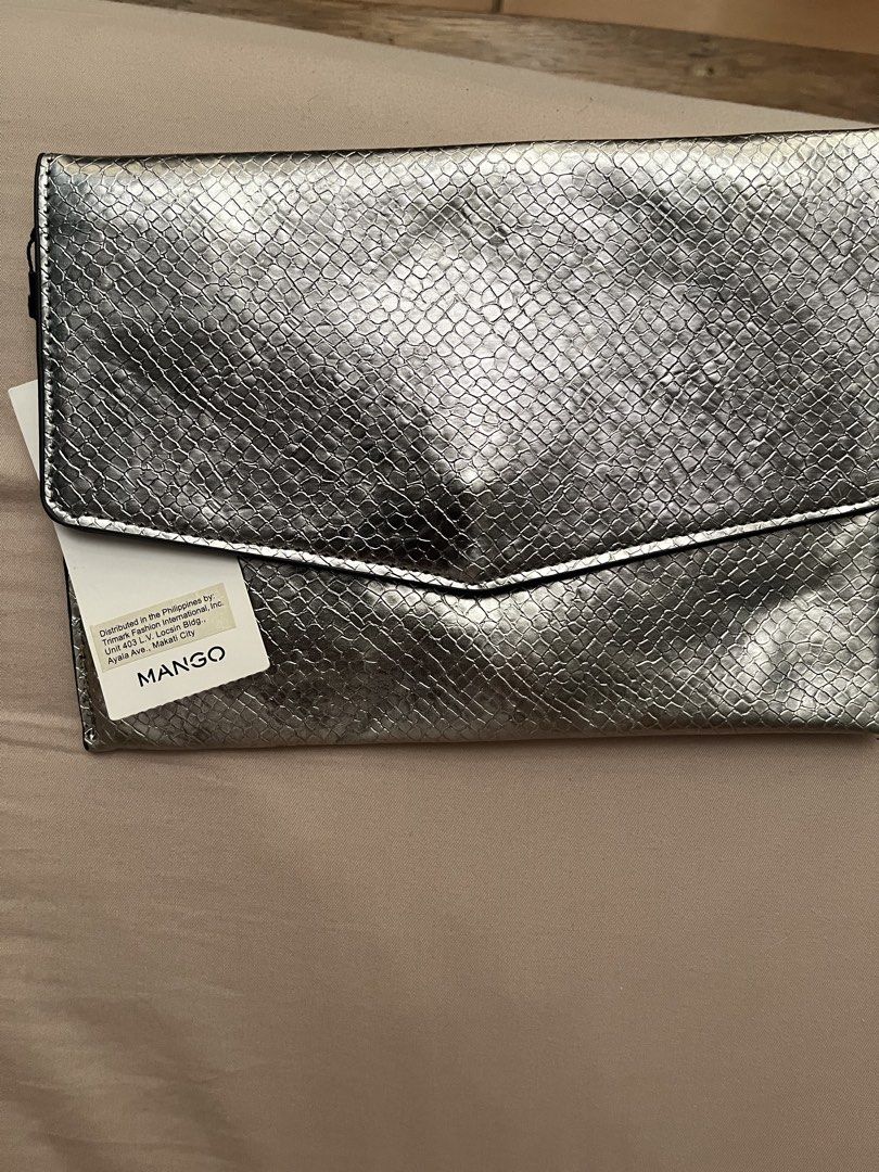 Mango Silver Snake Print Clutch Bag (Category: Clutches) located in Manila. Submitted by austinver91082 (Listing ID 1446543340, Image 1). Description: RFS : Decluttering - Chic silver clutch bag - Eye-catching snake print texture - Secure fold-over flap closure - Lined interior with Mango brand tag - Brand new with original tag attached - Ideal for evening events or adding flair to any outfit.