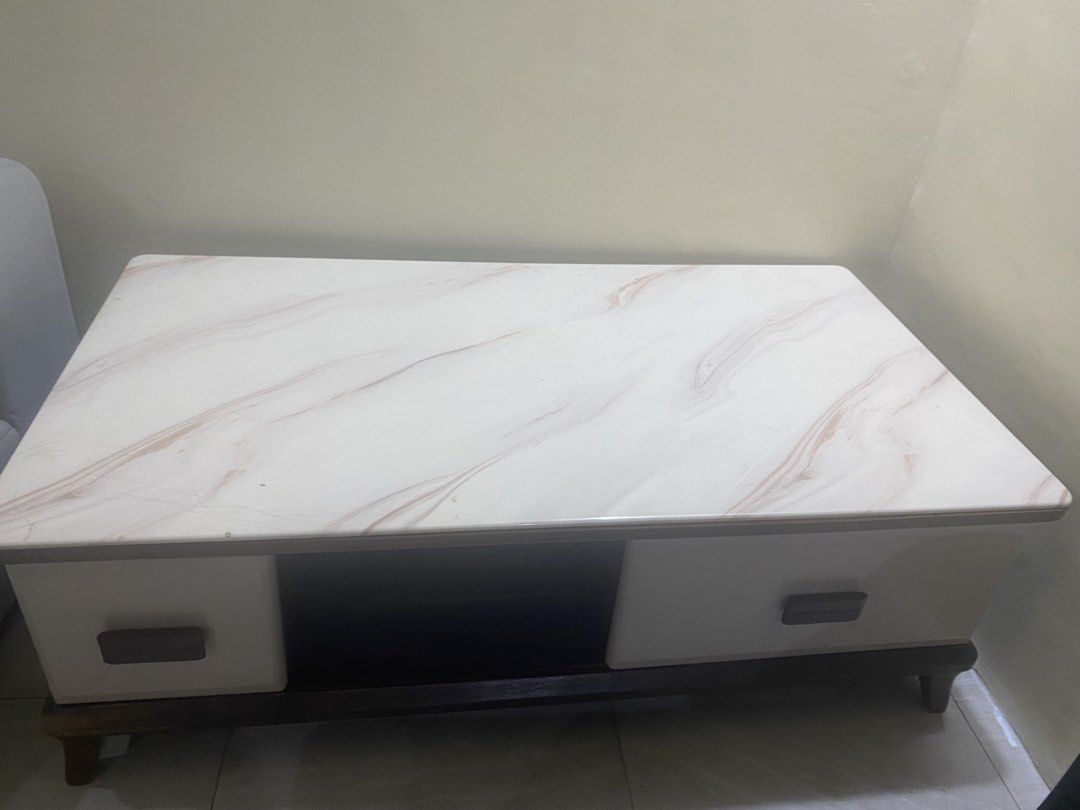 Marble Top Coffee Table with Drawers and Storage (Category: Tables & Sets) located in Mandaluyong City. Submitted by minimalist_mak (Listing ID 1446699466, Image 3). Description: - White marble top coffee table - Dark wood base and legs - Two drawers with wooden handles - Open storage space in the middle - Ideal for living room storage and display.