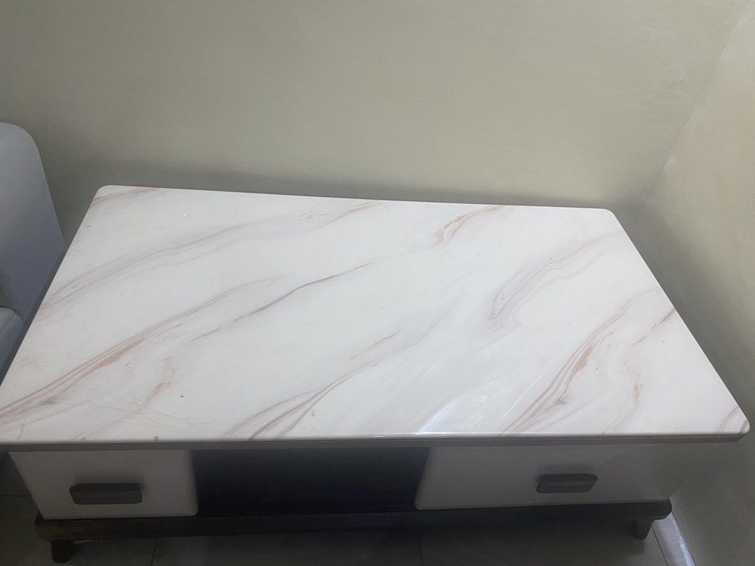 Marble Top Coffee Table with Drawers and Storage (Category: Tables & Sets) located in Mandaluyong City. Submitted by minimalist_mak (Listing ID 1446699466, Image 1). Description: - White marble top coffee table - Dark wood base and legs - Two drawers with wooden handles - Open storage space in the middle - Ideal for living room storage and display.