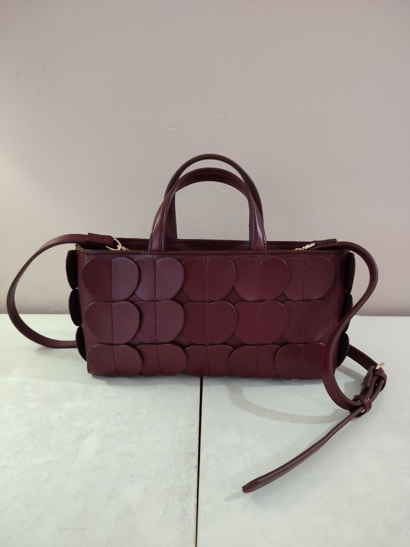 Maroon Handbag (Category: Shoulder Bags) located in Shah Alam. Submitted by ny985 (Listing ID 1446638577, Image 1). Description: ⚠️ no box, dustbag - Cute maroon handbag - Unique circle pattern on the sides - Top handles - Detachable shoulder strap - Zipper closure - Spacious interior - Perfect for everyday or a night out.