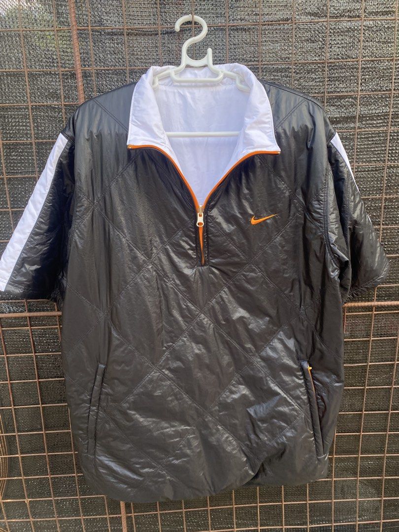 Nike Reversible Short Sleeve Jacket Black White Orange (Category: Coats, Jackets and Outerwear) located in Balanga. Submitted by vincentyy697259 (Listing ID 1446538863, Image 1). Description: - Reversible Nike Jacket - Size: Large (L) - Side 1: Black with quilted pattern and orange accents - Side 2: White with orange zipper - Short sleeves - Ideal for layering or as a light jacket.