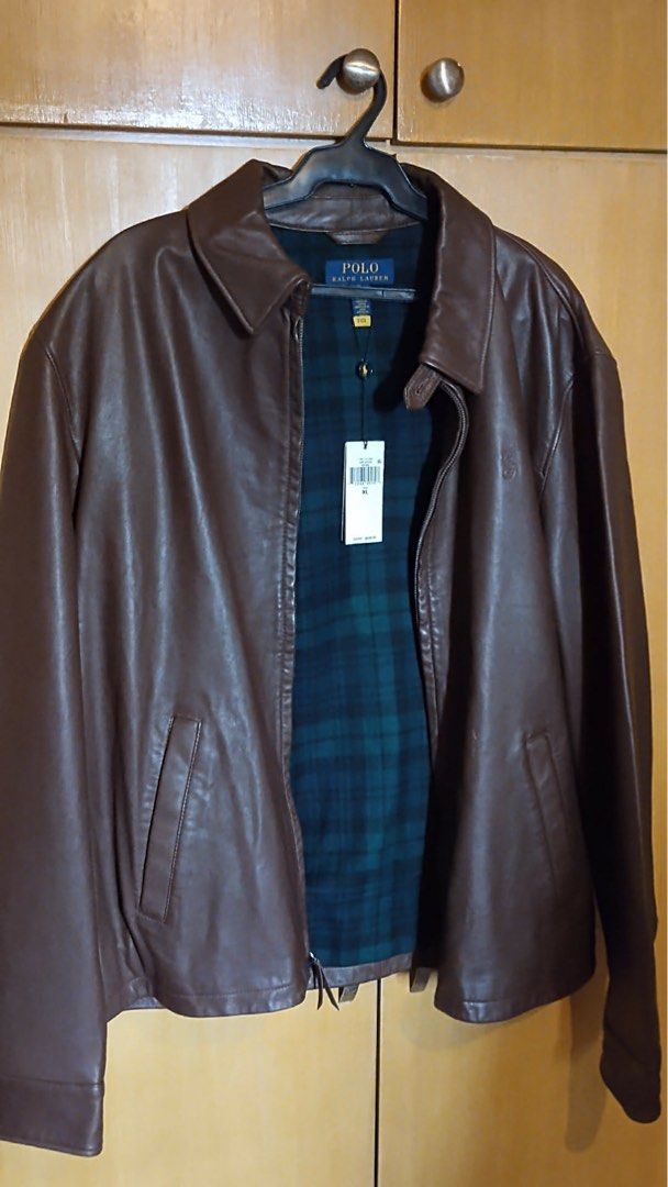 NWT Polo Ralph Lauren Brown Leather Jacket (Category: Coats, Jackets and Outerwear) located in Manila. Submitted by annann1003 (Listing ID 1446616488, Image 2). Description: - Classic brown leather jacket by Polo Ralph Lauren - Warm green and navy plaid lining - Zip-up front with two side pockets - Clean, simple back design - Ideal for cooler weather - Brand new with tags still attached -Retails for $700.