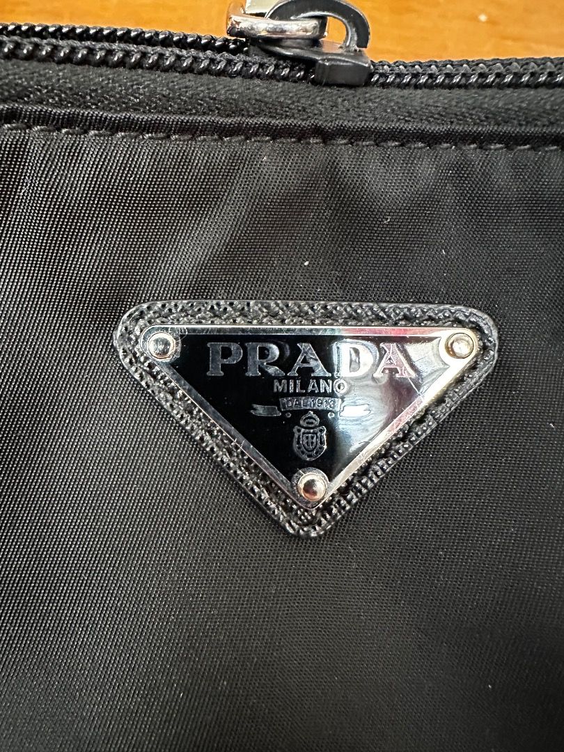 Authentic Prada Re-Nylon (Category: Luxury Bags & Wallets) located in Quezon City. Submitted by the_archive_luxe_ph (Listing ID 1446676393, Image 2). Description: Model: Prada modern Re-Nylon line Clutch/pouch Condition Rank: SA (Pristine / Like New) Year: 2021-2023 Material: Eco-Friendly Re-Nylon with Saffiano leather trim details Dimensions: Approx. 14.5 cm × 23 cm × 1 cm Details: RFID/Microchip Inclusions: Complete Full Set (Dust Bag, Aura Blo
