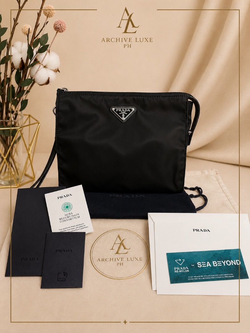Authentic Prada Re-Nylon (Category: Luxury Bags & Wallets) located in Quezon City. Submitted by the_archive_luxe_ph (Listing ID 1446676393, Image 1). Description: Model: Prada modern Re-Nylon line Clutch/pouch Condition Rank: SA (Pristine / Like New) Year: 2021-2023 Material: Eco-Friendly Re-Nylon with Saffiano leather trim details Dimensions: Approx. 14.5 cm × 23 cm × 1 cm Details: RFID/Microchip Inclusions: Complete Full Set (Dust Bag, Aura Blo