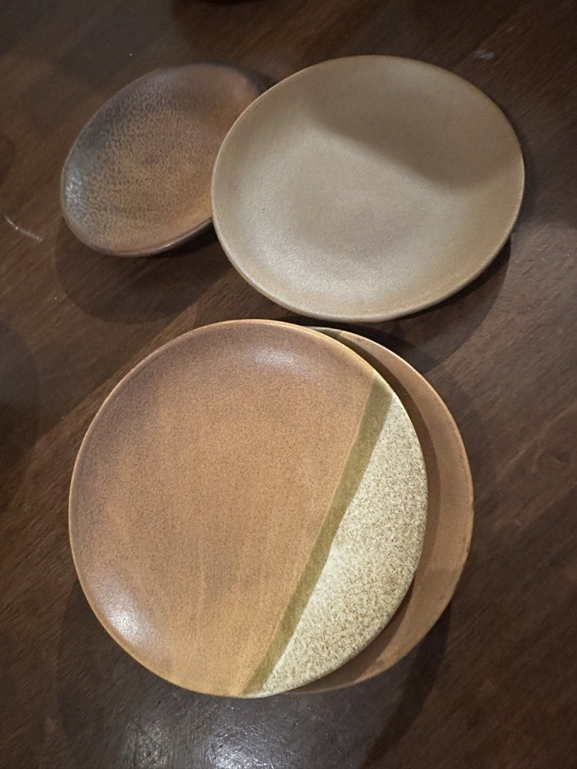 Set of 4 Ceramic Plates - Earth Tones (Category: Dinnerware & Cutlery) located in Manila. Submitted by kaitdeclutters (Listing ID 1446547722, Image 2). Description: - Set of 4 unique ceramic plates - Earthy tones with a rustic, handmade aesthetic - Two larger plates feature a gradient brown finish - One larger plate has a distinctive split design with textured lighter section - One smaller plate showcases a speckled dark brown finish - Ideal for 