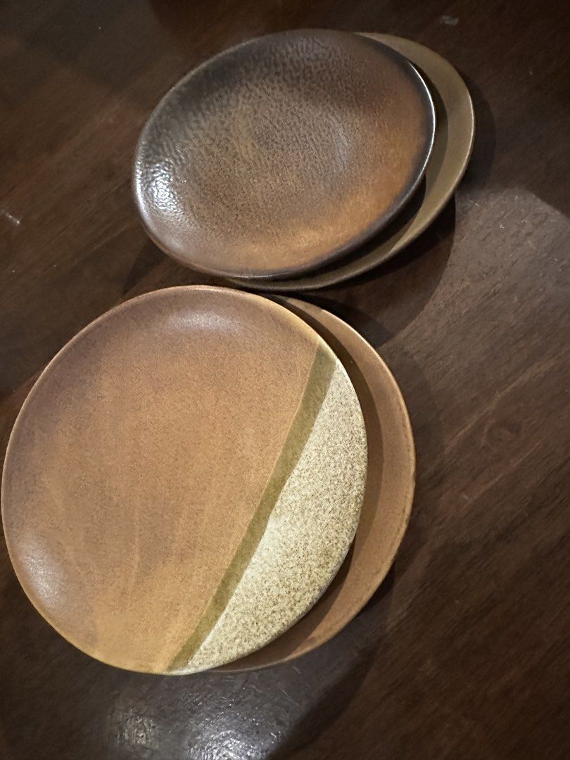 Set of 4 Ceramic Plates - Earth Tones (Category: Dinnerware & Cutlery) located in Manila. Submitted by kaitdeclutters (Listing ID 1446547722, Image 1). Description: - Set of 4 unique ceramic plates - Earthy tones with a rustic, handmade aesthetic - Two larger plates feature a gradient brown finish - One larger plate has a distinctive split design with textured lighter section - One smaller plate showcases a speckled dark brown finish - Ideal for 