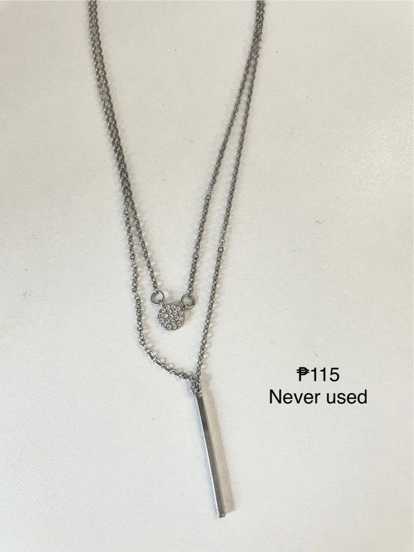 Stainless Steel Layered Necklace (Category: Necklaces) located in Manila. Submitted by hellonuggy (Listing ID 1446605325, Image 1). Description: - Two-layer necklace design - Features a small round pendant with tiny stones - Includes a sleek silver bar pendant - Made of durable stainless steel - Brand new, never used - Versatile for everyday wear or special occasions Rfs: double purchase Loc: commonwealth QC.