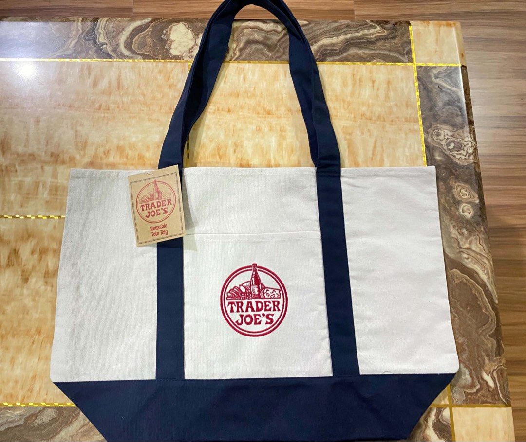 Trader Joe's Reusable Canvas Tote Bag (Category: Tote Bags) located in San Antonio. Submitted by pixiechromzzz (Listing ID 1446684847, Image 2). Description: - Trader Joe's reusable tote bag from CALIFORNIA, USA - Durable canvas material - Stylish navy blue trim and handles - Convenient front pocket with Trader Joe's logo - Proudly made in Vietnam - Ideal for grocery shopping and everyday use -both side pockets and etiketa .