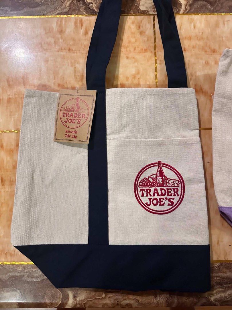 Trader Joe's Reusable Canvas Tote Bag (Category: Tote Bags) located in San Antonio. Submitted by pixiechromzzz (Listing ID 1446684847, Image 3). Description: - Trader Joe's reusable tote bag from CALIFORNIA, USA - Durable canvas material - Stylish navy blue trim and handles - Convenient front pocket with Trader Joe's logo - Proudly made in Vietnam - Ideal for grocery shopping and everyday use -both side pockets and etiketa .