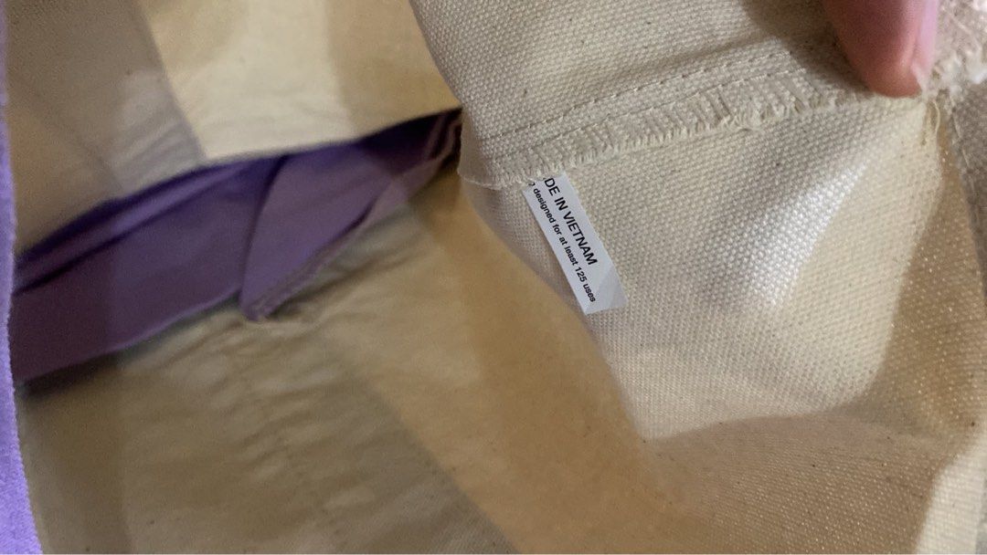 Trader Joe's Reusable Graphic Tote Bag (Category: Tote Bags) located in San Antonio. Submitted by pixiechromzzz (Listing ID 1446685003, Image 3). Description: - Trader Joe's Canvas Tote Bag from CALIFORNIA, USA - Color: Cream with purple accents - Features embroidered Trader Joe's logo on front - Includes a convenient front pocket - Material: 60% Cotton, 20% Polyester - Ideal for grocery shopping or everyday errands - Made in Vietnam.