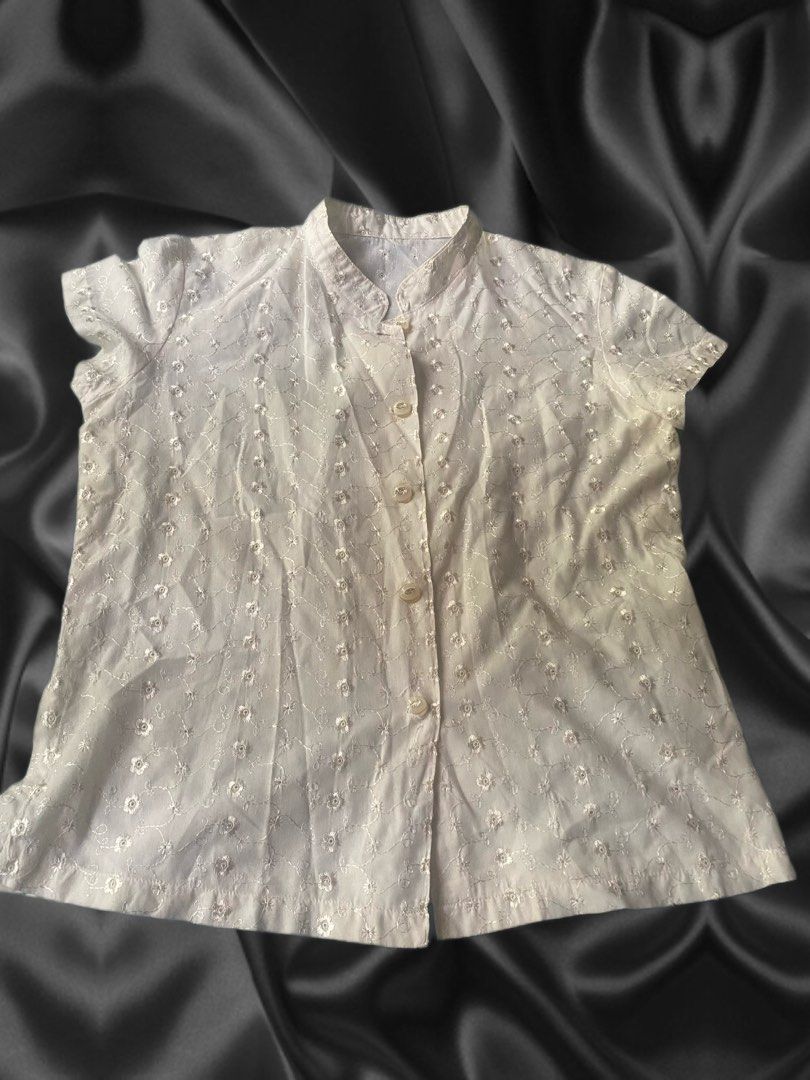 White Floral Eyelet Embroidered Blouse (Category: Blouses) located in Paranaque City. Submitted by hershop.sbt (Listing ID 1446538925, Image 1). Description: * Color: Beige * Style: Short-sleeve button-up blouse * Mandarin (band) collar * Front button closure * All-over floral eyelet embroidery * Soft front design * Lightweight and breathable fabric * Relaxed fit * Perfect for casual wear, office attire, or smart-casual occasions.