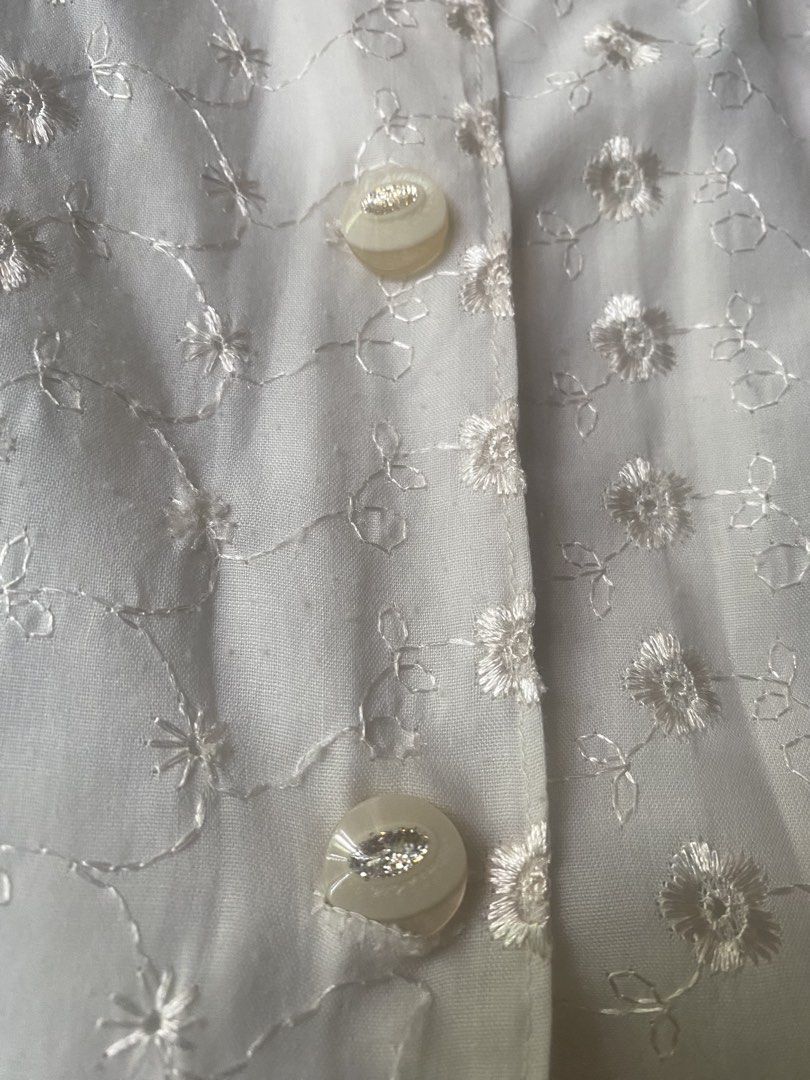 White Floral Eyelet Embroidered Blouse (Category: Blouses) located in Paranaque City. Submitted by hershop.sbt (Listing ID 1446538925, Image 2). Description: * Color: Beige * Style: Short-sleeve button-up blouse * Mandarin (band) collar * Front button closure * All-over floral eyelet embroidery * Soft front design * Lightweight and breathable fabric * Relaxed fit * Perfect for casual wear, office attire, or smart-casual occasions.