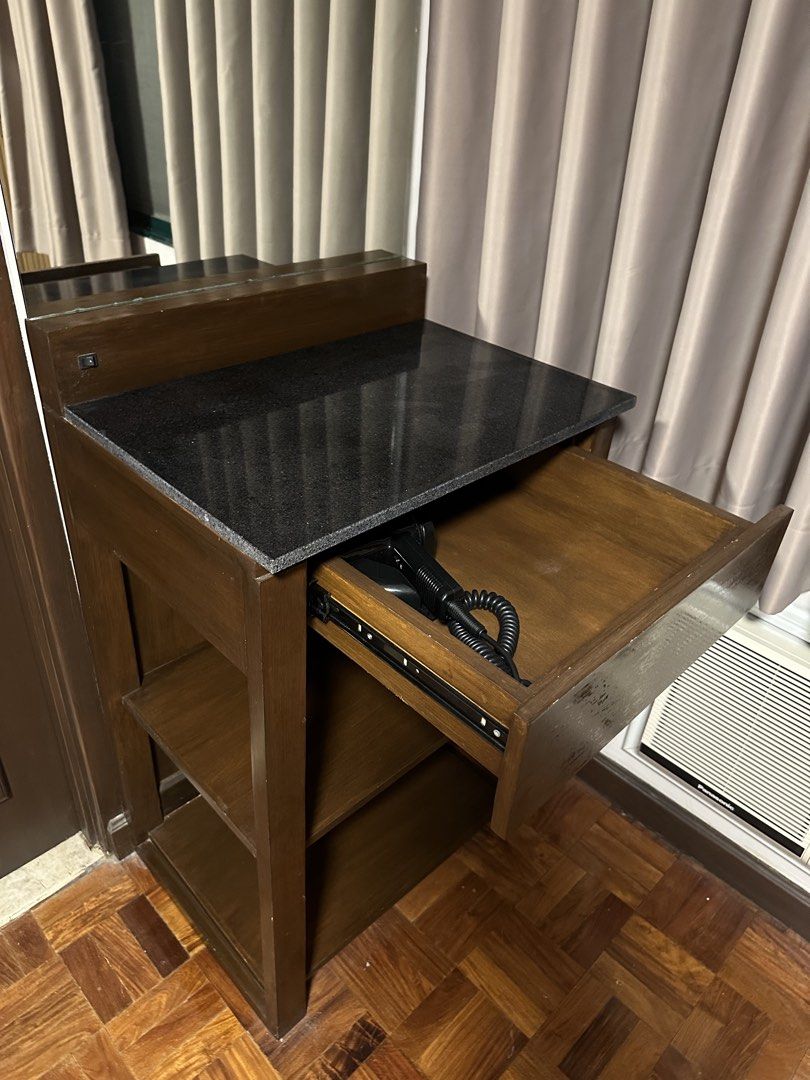 Wooden Vanity Table with Granite Top and Mirror (Category: Tables & Sets) located in Taguig. Submitted by kristeta85 (Listing ID 1446591433, Image 3). Description: - Compact wooden vanity table - Features a dark granite top - Two open shelves for storage - Includes a mirror above the top - Pull-out drawer for additional storage - Ideal for small spaces - 60cm W x 47cm D x 90cm H of table - 193cm H total height with mirror - RFS: Redecorating - Pi