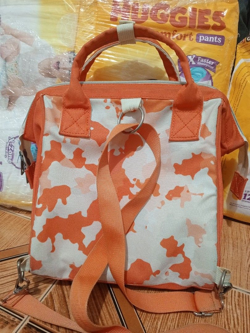 Yoboo Camouflage Diaper Bag Backpack Orange White (Category: Diaper Bags & Wetbags) located in Quezon City. Submitted by via_rama18 (Listing ID 1446679903, Image 2). Description: - Stylish orange and white camouflage diaper bag. - Convenient front zipper pocket for quick access. - Spacious main compartment with multiple internal pockets for organization. - Versatile carrying options: can be used as a handbag or a backpack. - Adjustable straps for