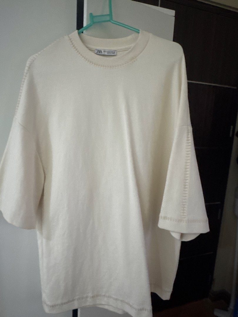 ZARA Cream Oversized T-Shirt (Category: Others Tops) located in Binan City. Submitted by mituz (Listing ID 1446544927, Image 1). Description: - Cream colored t-shirt from ZARA - Size: Medium - Fit: Relaxed, oversized - Features: Unique stitching detail on neckline and sleeves - Origin: Made in Turkey - Style: Essential wardrobe basic.