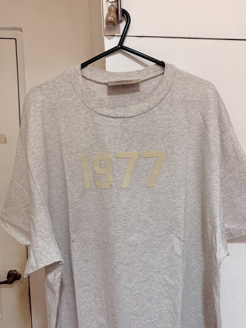 (Authentic) Essentials Fear of God 1977 Shirt Heather Grey (Category: Tshirts & Polo Shirts ) located in Cavite. Submitted by kumbin (Listing ID 1441611551, Image 1). Description: Essentials Fear of God 1977 Shirt (100% legit) Not thrifted, first owner Heather grey color, soft heavy fabric 🩶 Dimensions: 24 by 30 inches (XL fitting) Issue: Altered, kaya nawala na yung tags. (L on tag kasi ito and sobrang laki kaya pina alter ko ng size ko). Kaya 