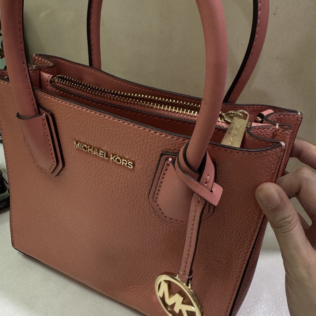 Authentic Michael Kors Pink Peach Leather Tote Bag (Category: Luxury Bags & Wallets) located in Quezon City. Submitted by kb0030 (Listing ID 1441685049, Image 2). Description: Stored only With minor scuff on handle - Michael Kors Mini tote bag in a beautiful pink shade. - Crafted from durable pebbled leather. - Elegant gold-tone hardware with signature MK charm. - Secure top zipper closure. - Interior features one zippered pocket and one slip poc