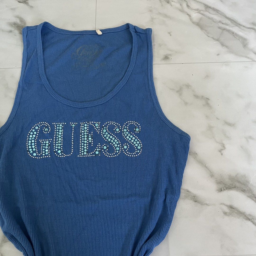 Blue Guess Tank Top with Rhinestone Logo (Category: Sleeveless) located in Manila. Submitted by giormagne (Listing ID 1441609486, Image 2). Description: - Blue ribbed Guess tank top - Features Guess logo with sparkling rhinestones - Sleeveless design - Ideal for casual wear - Pairs well with jeans or shorts.