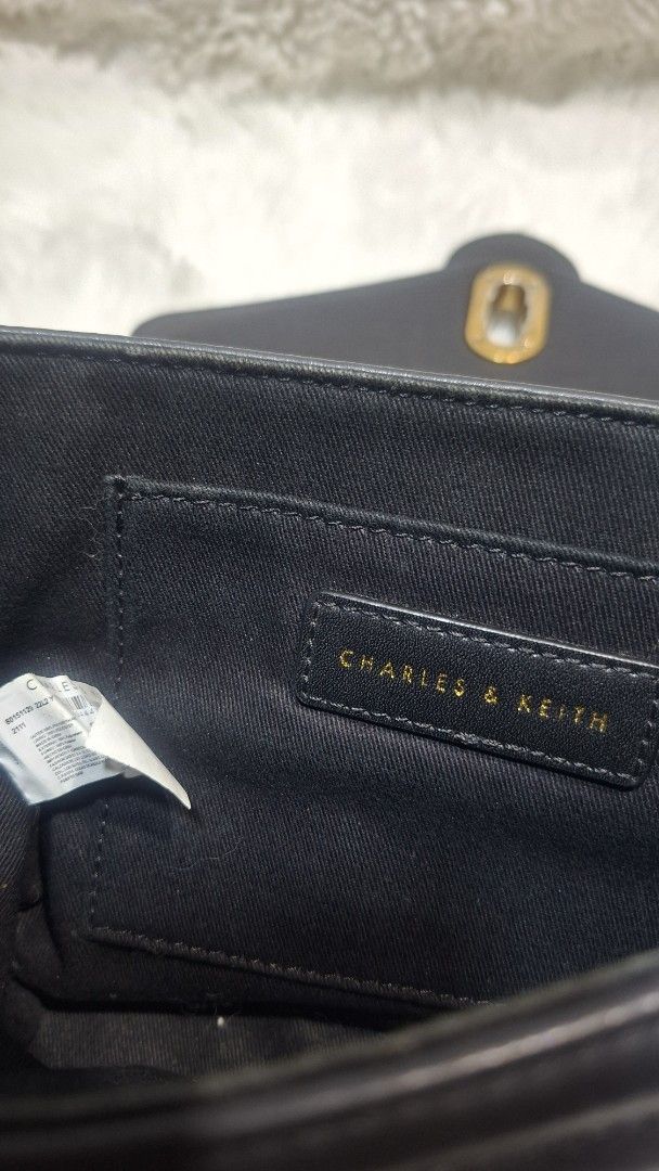 Charles & Keith Black Quilted Chain Shoulder Bag (Category: Shoulder Bags) located in Panabo. Submitted by Djars_Finds (Listing ID 1441750705, Image 2). Description: - Black quilted shoulder bag by Charles & Keith - Elegant gold chain strap - Secure buckle closure - Interior brand label - Approx. 8" W x 5" H - Versatile for nights out or daily wear - This are thrifted items so manage your expectation unless stated - What you see is what you get -