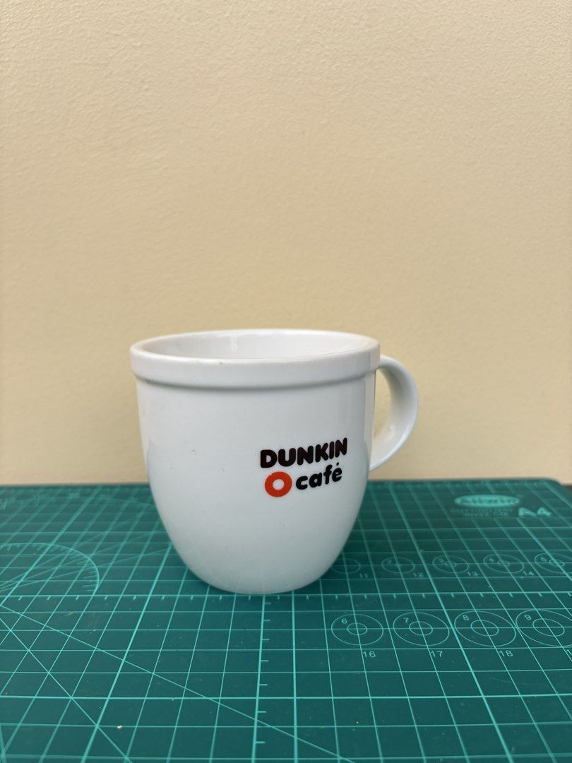 Dunkin' Cafe White Ceramic Coffee Mug (Category: Coffee & Tea Tableware) located in Antipolo. Submitted by anabri (Listing ID 1441678940, Image 1). Description: - White ceramic mug from Dunkin' Cafe - Features the iconic Dunkin' logo - Sturdy handle for a comfortable grip - See photos for details.