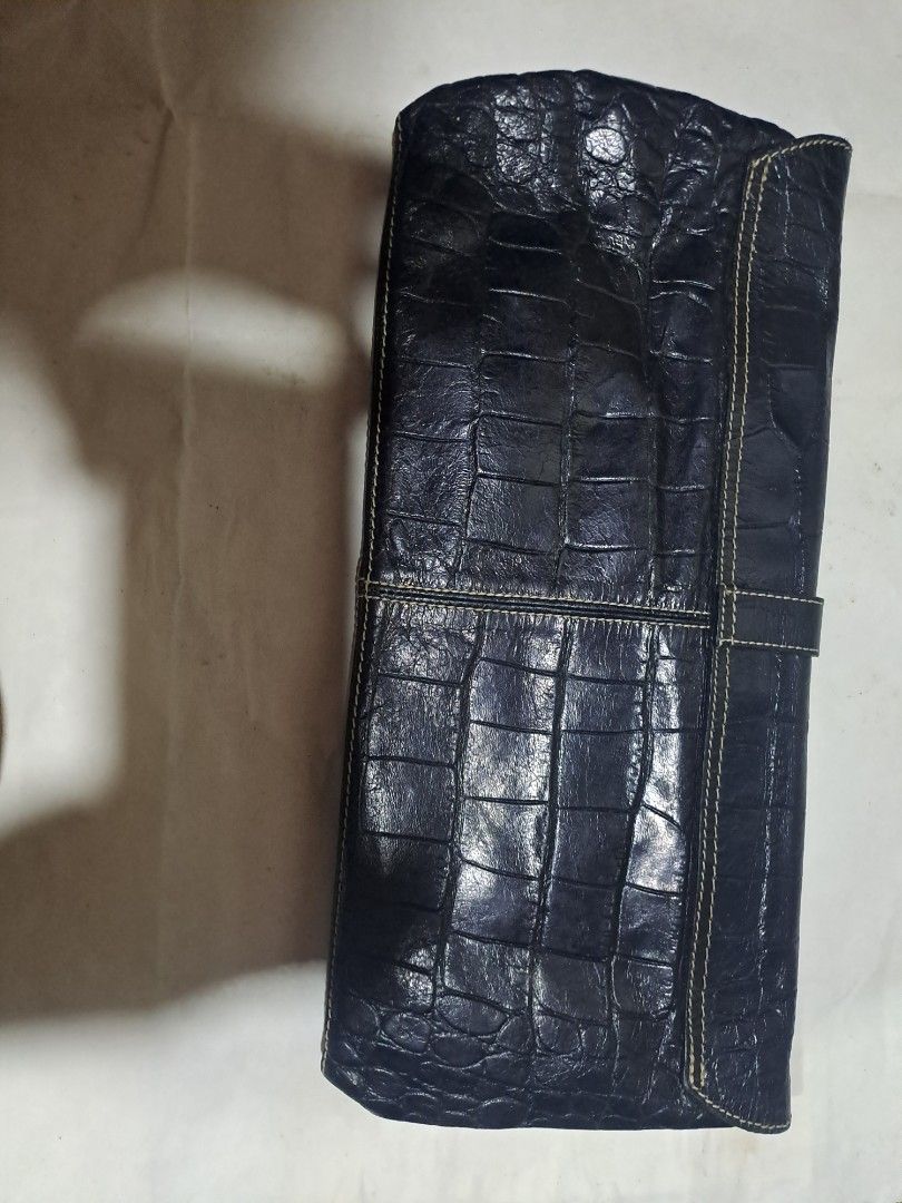 Enzo Pull Black Crocodile Embossed Leather Clutch Bag (Category: Luxury Bags & Wallets) located in Davao. Submitted by bravemoon_556cd5 (Listing ID 1441741564, Image 3). Description: - Elegant black clutch bag - Luxurious crocodile embossed texture - Secure buckle closure on front flap - Interior Enzo Poli logo - Ideal for evening events or as a statement accessory - Dimensions: Approximately 13 inches wide x 6 inches tall (when closed).