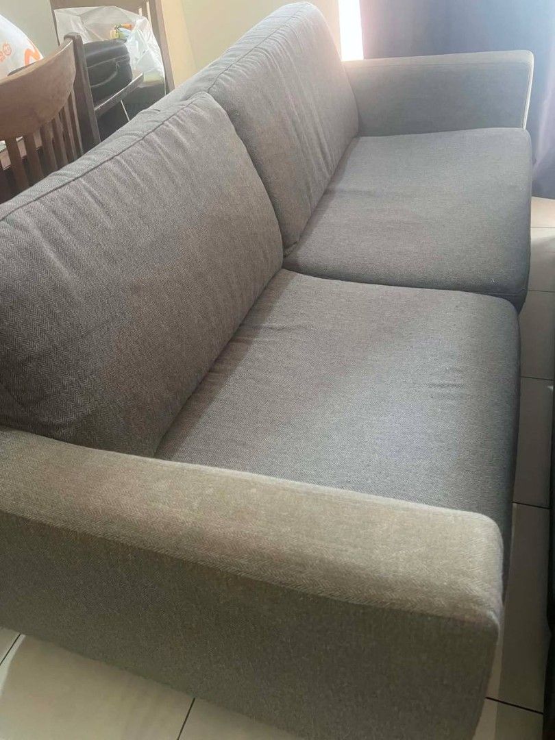 Gray Couch [With Issue] (Category: Sofas) located in Taguig. Submitted by belle8816 (Listing ID 1441596861, Image 1). Description: - Comfortable grey fabric sofa - Seats three people - Plush cushions and soft fabric - Modern design, fits most living rooms - Ideal for lounging or entertaining - With issue: wooden support underneath broken. need reinforcement/refurbishing. otherwise, good condition - Loc is Sheridan Mandaluyong.