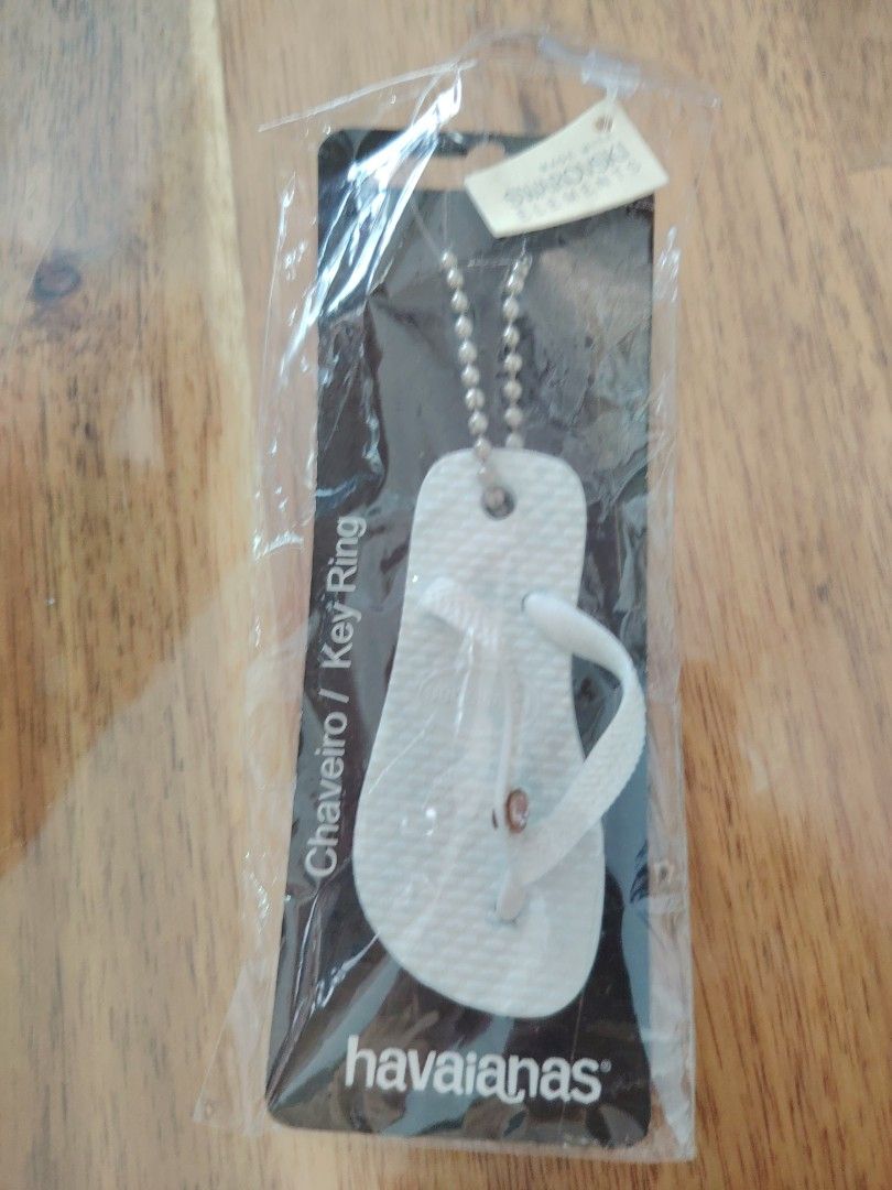Havaianas White Flip Flop/Slippers Keychain with Swarovski Crystal (Category: Flipflops and Slides) located in Singapore. Submitted by wantanmee_88 (Listing ID 1441657237, Image 2). Description: - Cute Havaianas keychain - Shaped like a mini white flip flop - Features a small Swarovski crystal on the strap - Includes original packaging and tag - Ideal for personalizing keys or bags - Dimensions: Approximately 6.8cm (length) x 3cm (width) *minor b