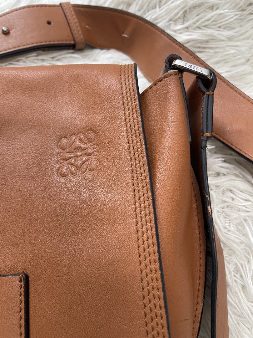 Loewe Tan Leather Shoulder Bag (Category: Luxury Bags & Wallets) located in Quezon City. Submitted by impulse.ph (Listing ID 1441778744, Image 2). Description: Loewe Military Messenger tan leather shoulder bag - Iconic Anagram logo embossed on front flap - Adjustable leather strap - Suede lining with interior zipped pocket - Made in Spain - Classic and versatile for everyday wear ***IT HAS MINOR DIRTS BUT I GUESS IT CAN BE CLEANED. PLEASE SEE UPL