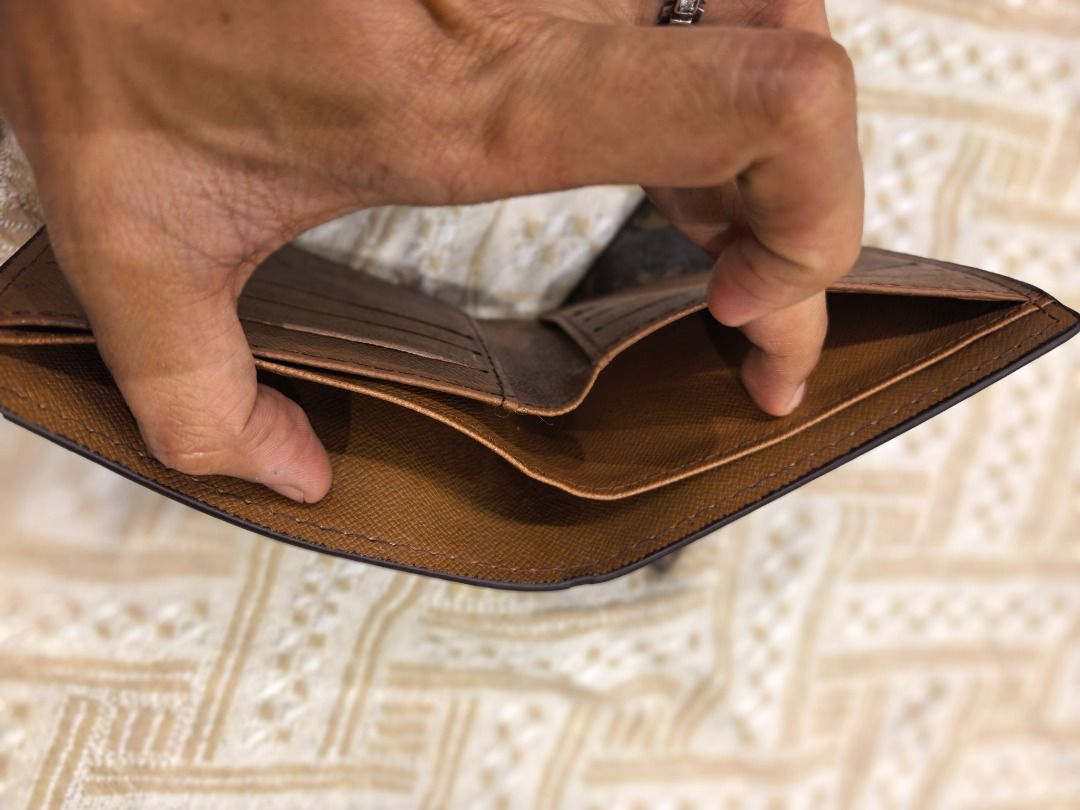 Lv Monogram Bifold Wallet (Category: Luxury Bags & Wallets) located in Cebu City. Submitted by esrpreloved (Listing ID 1441747767, Image 2). Description: - L Vmonogram bifold wallet - Color: Brown canvas with tan interior - Features: Multiple card slots, bill compartment - Condition: Shows some signs of wear on canvas and interior edges, still functional and stylish - Includes: Separate cardholder.