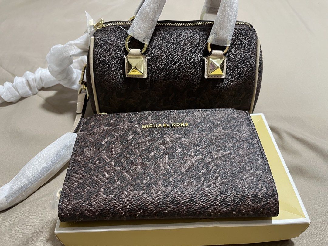 Michael Kors Monogram Barrel Bag with Matching Wallet (Category: Cross-body Bags) located in Pasig City. Submitted by melaiski28 (Listing ID 1441628701, Image 2). Description: - Brown monogram barrel bag and matching zip-around wallet set. - Features elegant gold hardware details. - Comes with original dust bag and packaging. - Bag includes a comfortable top handle and a detachable crossbody strap for versatile carrying. - Wallet offers multiple 