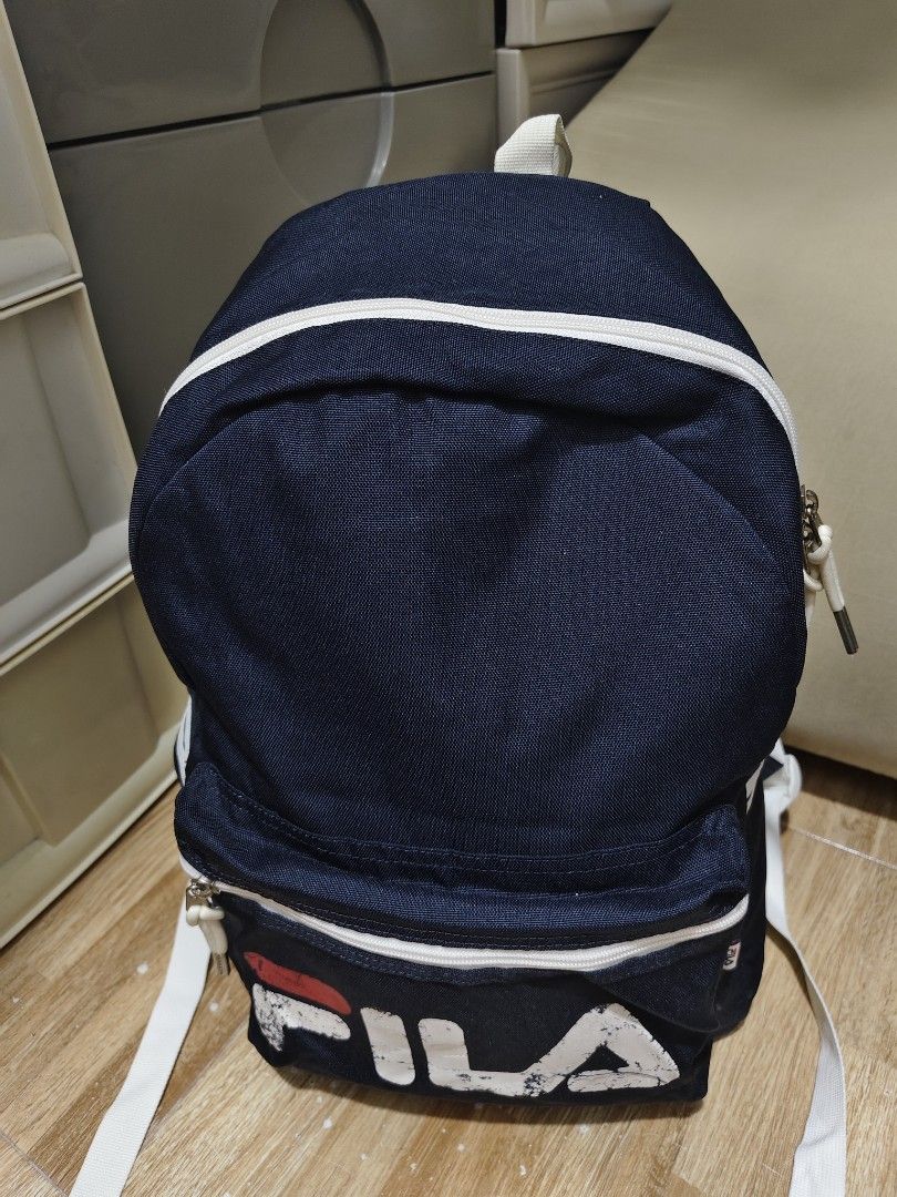 Navy Fila Backpack with White Accents (Category: Backpacks) located in Makati City. Submitted by abegailbrezuela (Listing ID 1441622103, Image 3). Description: - Classic navy Fila backpack - Iconic Fila logo on front pocket - White piping and straps for contrast - Two zippered compartments for storage - Adjustable shoulder straps for comfort - Ideal for school or everyday use.