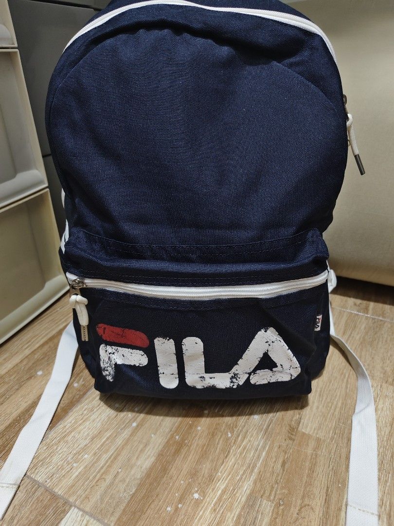 Navy Fila Backpack with White Accents (Category: Backpacks) located in Makati City. Submitted by abegailbrezuela (Listing ID 1441622103, Image 2). Description: - Classic navy Fila backpack - Iconic Fila logo on front pocket - White piping and straps for contrast - Two zippered compartments for storage - Adjustable shoulder straps for comfort - Ideal for school or everyday use.