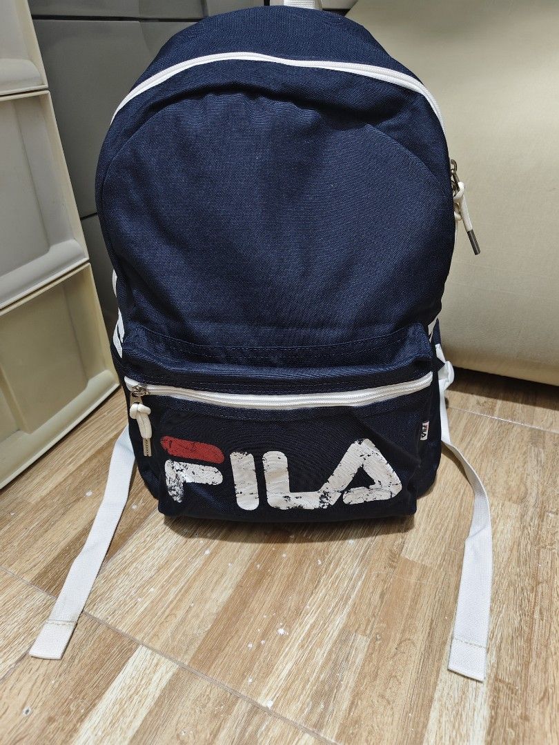 Navy Fila Backpack with White Accents (Category: Backpacks) located in Makati City. Submitted by abegailbrezuela (Listing ID 1441622103, Image 1). Description: - Classic navy Fila backpack - Iconic Fila logo on front pocket - White piping and straps for contrast - Two zippered compartments for storage - Adjustable shoulder straps for comfort - Ideal for school or everyday use.