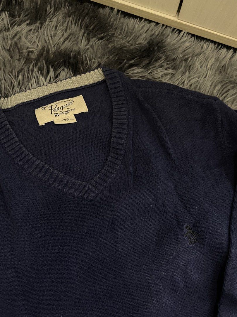 Original Penguin, V-Neck Navy Blue Sweater (Category: Coats, Jackets and Outerwear) located in Quezon City. Submitted by izxbll_declutters (Listing ID 1441723245, Image 2). Description: - Original Penguin by Munsingwear V-neck sweater - Deep navy blue color - Signature embroidered penguin logo on chest - Ribbed cuffs and hem with subtle stripe detail - Size: Large - Perfect for layering or standalone wear.
