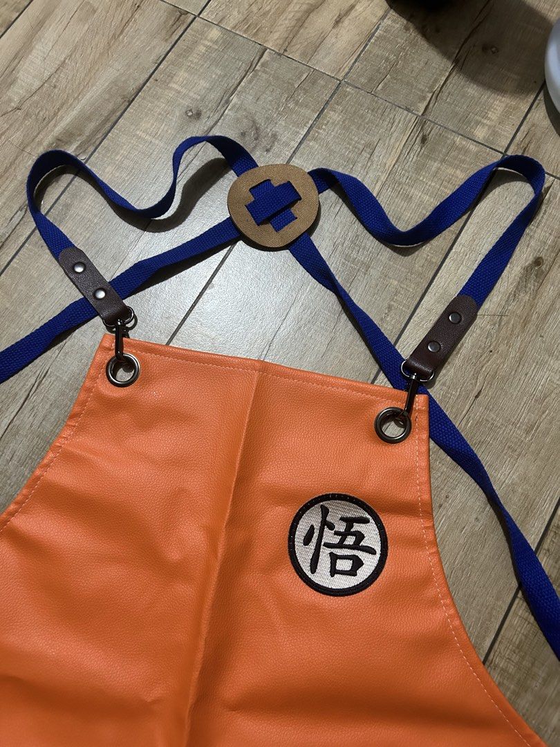 Rare DBZ Dragon Ball Z Goku Inspired Orange Leather Apron (Category: Toys & Games) located in Paranaque City. Submitted by zac.sei (Listing ID 1441712399, Image 3). Description: - Orange apron featuring the iconic Goku Kanji symbol. - Classy and awesome look - Adjustable straps with stylish leather accents. - Convenient chest pocket and a small front pocket. - Ideal for both cooking enthusiasts and cosplay fans. - Made from durable, easy-to-clean
